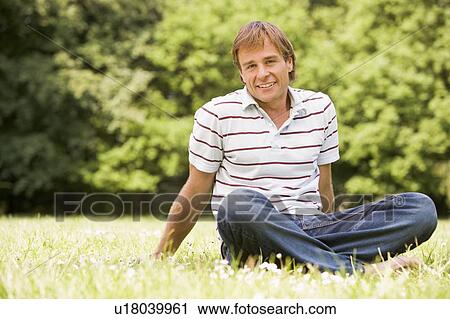 Man sitting outdoors smiling View Large Photo Image Stock Image - Man sitting outdoors smiling. Fotosearch