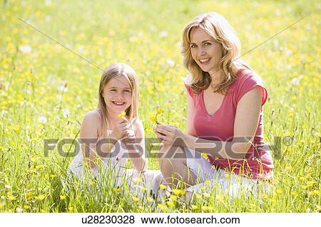 Mother and daughter outdoors holding flower smiling View Large Photo Image Stock Photo - Mother and daughter outdoors holding flower smiling. Fotosearch
