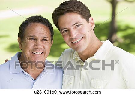 Stock Image - Two men standing outdoors smiling. Fotosearch