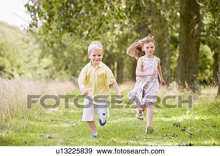 Stock Photo - Two young children running on path smiling. Fotosearch