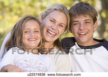 Woman and two young children outdoors laughing View Large Photo Image Stock Photograph - Woman and two young children outdoors laughing. Fotosearch