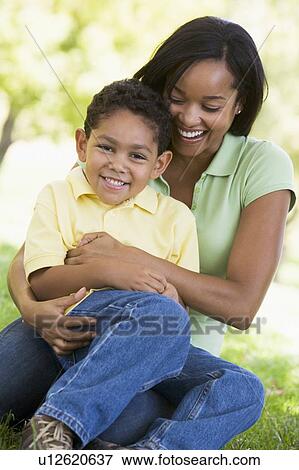 Stock Photo - Woman and young boy outdoors embracing and smiling. Fotosearch