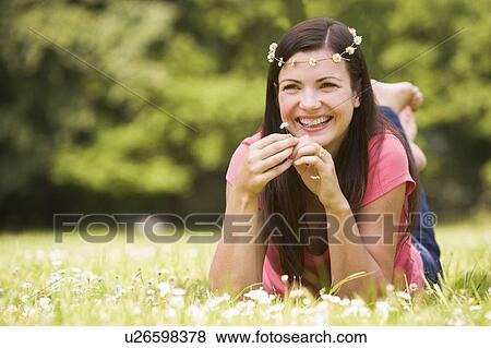 Woman lying outdoors with flowers smiling View Large Photo Image Stock Photo - Woman lying outdoors with flowers smiling. Fotosearch
