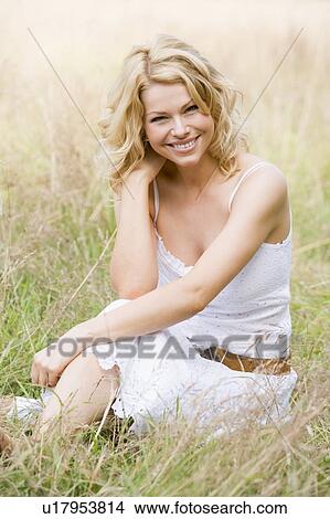 Woman sitting outdoors smiling View Large Photo Image Picture - Woman sitting outdoors smiling. Fotosearch