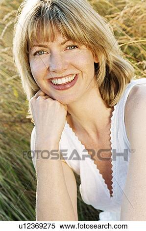 Woman sitting outdoors smiling View Large Photo Image Stock Photography - Woman sitting outdoors smiling. Fotosearch