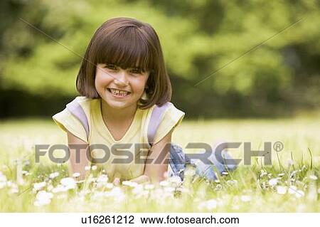 Young girl lying outdoors smiling View Large Photo Image Stock Image - Young girl lying outdoors smiling. Fotosearch