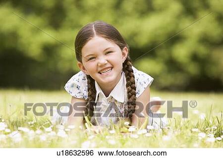 Young girl lying outdoors smiling View Large Photo Image Stock Photograph - Young girl lying outdoors smiling. Fotosearch