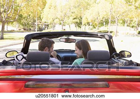 Stock Image - Couple in convertible car smiling. Fotosearch