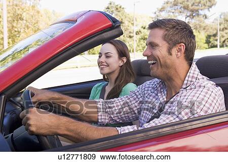 Couple in convertible car smiling View Large Photo Image Stock Photo - Couple in convertible car smiling. Fotosearch