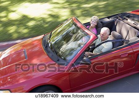 Stock Photo - Couple in convertible car smiling. Fotosearch