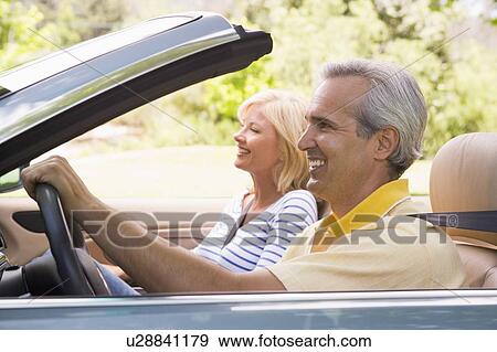 Couple in convertible car smiling View Large Photo Image Stock Photo - Couple in convertible car smiling. Fotosearch