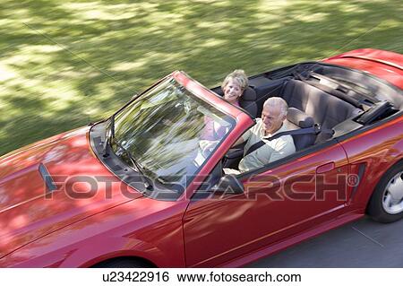 Stock Photograph - Couple in convertible car smiling. Fotosearch