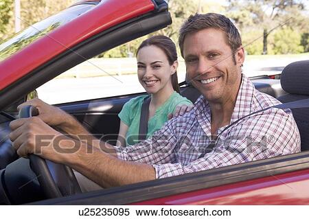 Stock Photography - Couple in convertible car smiling. Fotosearch