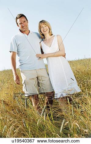 Couple standing outdoors smiling View Large Photo Image Stock Photo - Couple standing outdoors smiling. Fotosearch