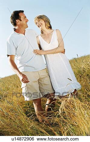 Stock Photograph - Couple standing outdoors smiling. Fotosearch