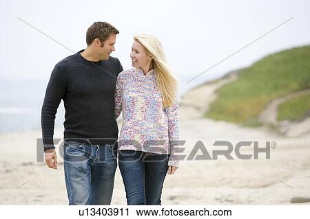 Couple walking at beach smiling View Large Photo Image Stock Image - Couple walking at beach smiling. Fotosearch