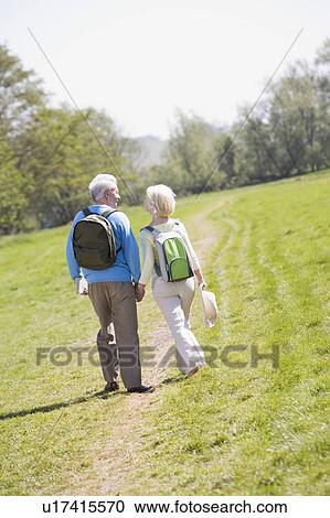 Couple walking on path in park holding hands View Large Photo Image Stock Image - Couple walking on path in park holding hands. Fotosearch