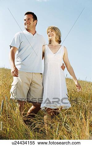 Stock Photography - Couple walking outdoors smiling. Fotosearch
