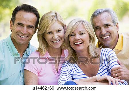Two couples outdoors smiling View Large Photo Image Stock Photo - Two couples outdoors smiling. Fotosearch