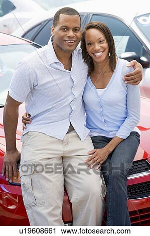 Stock Image - Young couple shopping for a new car. Fotosearch