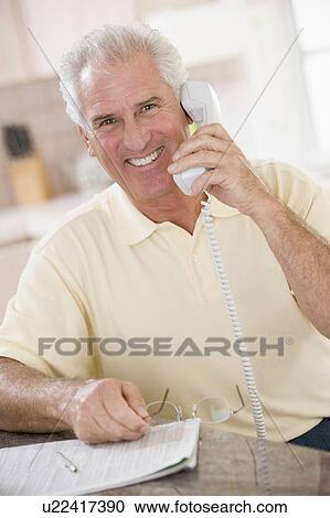 Man in kitchen on telephone smiling View Large Photo Image Stock Image - Man in kitchen on telephone smiling. Fotosearch