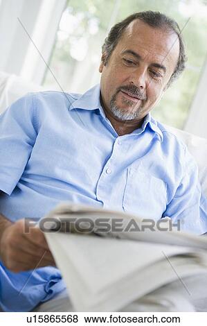 Man in living room with newspaper (high key/selective focus) View Large Photo Image Stock Photo - Man in living room with newspaper (high key/selective focus). Fotosearch