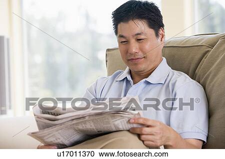 Stock Image - Man relaxing with a newspaper. Fotosearch