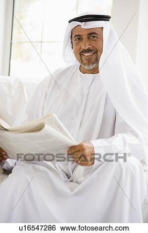 Man sitting indoors with newspaper smiling (high key/selective focus) View Large Photo Image Stock Photograph - Man sitting indoors with newspaper smiling (high key/selective focus). Fotosearch