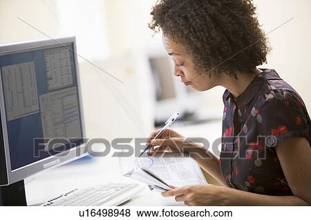 Woman in computer roon circling items in newspaper View Large Photo Image Stock Photo - Woman in computer roon circling items in newspaper. Fotosearch