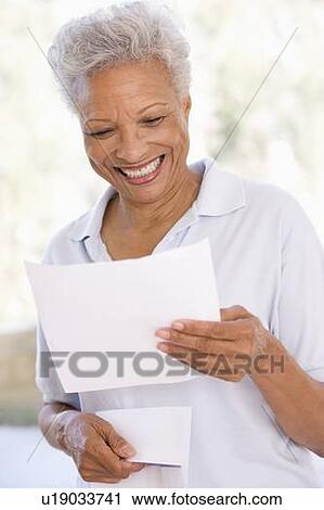 Woman reading letter smiling View Large Photo Image Stock Image - Woman reading letter smiling. Fotosearch