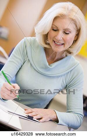 Adult student in class taking notes View Large Photo Image Stock Photo - Adult student in class taking notes. Fotosearch