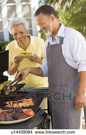 Couple Cooking On A Barbeque View Large Photo Image Picture - Couple Cooking On A Barbeque. Fotosearch