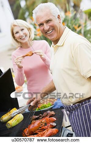 Couple Cooking On A Barbeque View Large Photo Image Stock Photo - Couple Cooking On A Barbeque. Fotosearch