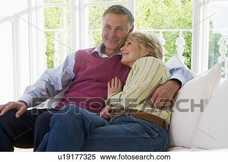 Stock Photography - Couple in living room smiling. Fotosearch