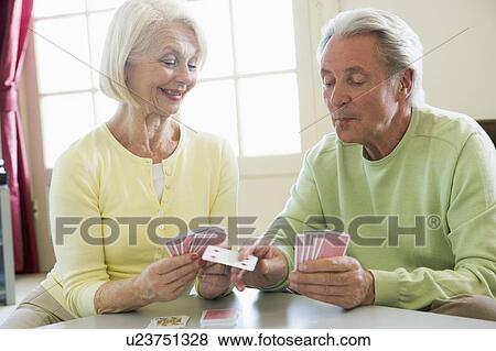 Couple playing cards in living room smiling View Large Photo Image Stock Photo - Couple playing cards in living room smiling. Fotosearch