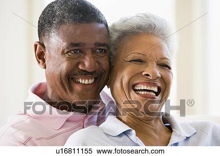Couple relaxing in living room and smiling View Large Photo Image Stock Photography - Couple relaxing in living room and smiling. Fotosearch