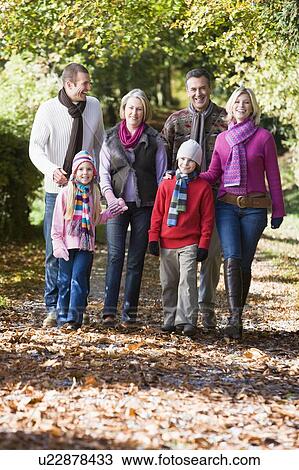 Stock Image - Family walking outdoors in park and smiling. Fotosearch