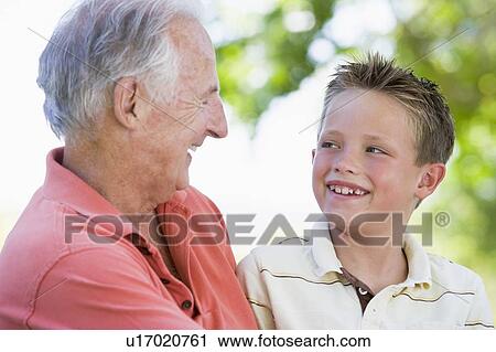 Grandfather and grandson smiling outdoors. View Large Photo Image Stock Image - Grandfather and grandson smiling outdoors.. Fotosearch