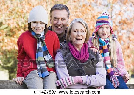 Stock Photo - Grandparents with grandchildren outdoors in park smiling (selective focus). Fotosearch