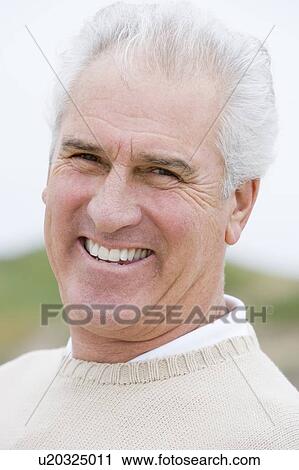 Stock Image - Man at the beach smiling. Fotosearch