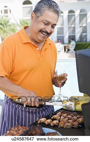 Stock Photo - Man Barbequing In A Garden. Fotosearch