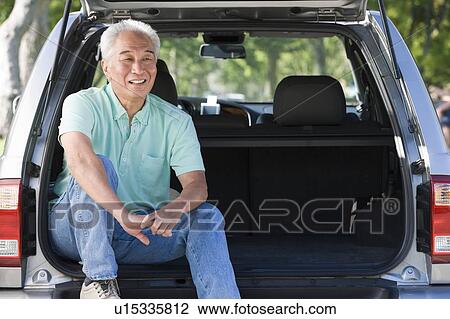 Man sitting in back of van smiling View Large Photo Image Stock Image - Man sitting in back of van smiling. Fotosearch