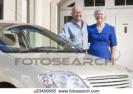 Senior couple standing with their car outside their home View Large Photo Image Stock Image - Senior couple standing with their car outside their home. Fotosearch