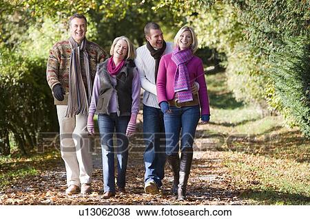 Stock Photo - Two couples walking outdoors in park and smiling. Fotosearch