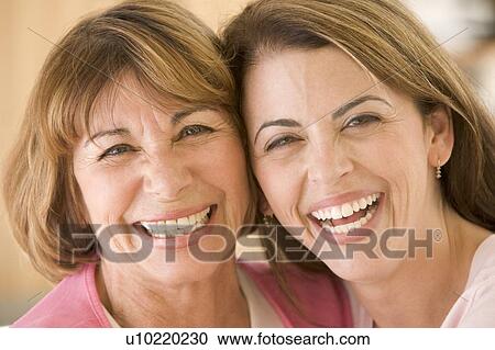 Two women in living room smiling View Large Photo Image Stock Image - Two women in living room smiling. Fotosearch