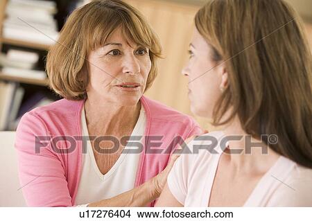 Picture - Two women sitting in living room talking. Fotosearch