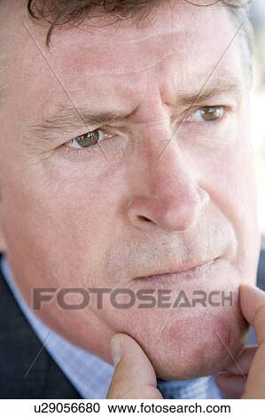 Stock Image - Head shot of man thinking. Fotosearch