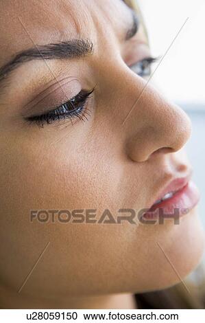 Stock Image - Head shot of woman scowling. Fotosearch