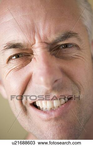Stock Image - Head shot of man scowling. Fotosearch