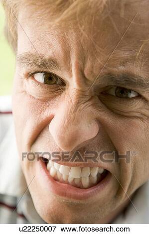 Stock Photo - Head shot of man scowling. Fotosearch